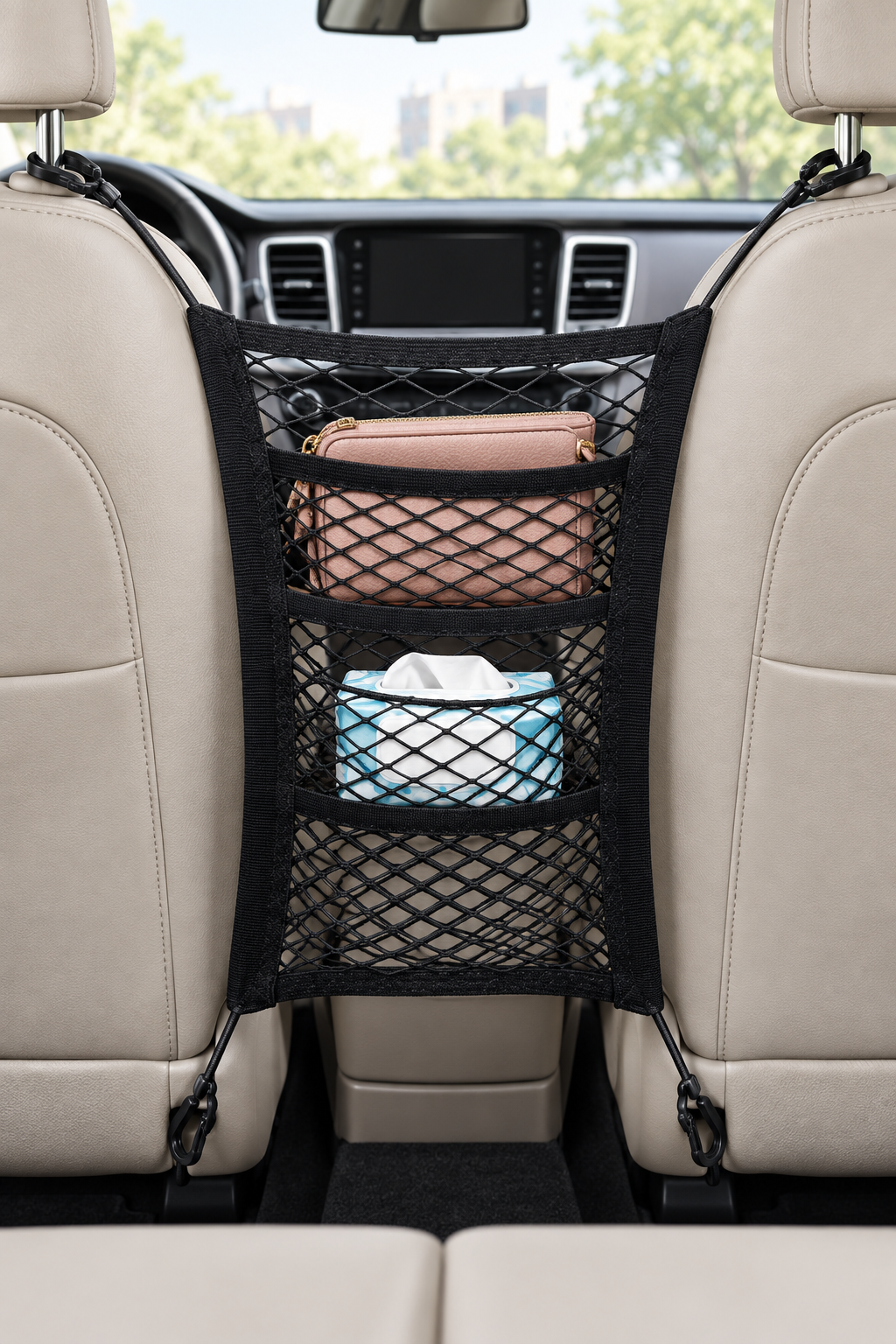 Three-layer black stretch mesh organizer spanning the space between two front seats, holding a purse and tissues.